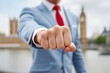 © Ben - Businessman punching forward with government building background symbolizing political confrontation, leadership power struggle, governmental authority competition and strategic national influence con