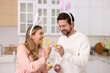 © New Africa - Easter celebration. Happy couple with painted eggs in kitchen