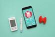 © Pixel-Shot - Mobile phone with glucometer, lancet pen and thyroid gland model on green background. Endocrinology concept