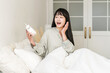 © buritora - Young asian woman surprised and surprised when she sees her alarm clock (oversleep, lateness, oversleeping)