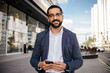 © kleberpicui - Confident adult business man using a smartphone in a modern urban environment. Concepts of success, communication, professional lifestyle and technology.