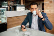© kleberpicui - Adult business man drinking coffee in a cafe while checking his smartphone. Concepts of work break, lifestyle, remote work, communication and routine.