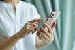 © maaagram - スマホを操作する女性の手元　Woman's hand operating a cell phone　Generative AI