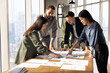 © fizkes - Multiethnic team of analysts working on paper sales reports, analyzing marketing research results, discussing strategy of growth, development, effective business plan, investment