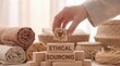 © VisiNode Studio - Hand arranging wooden blocks with ethical sourcing concept and textile products in a natural setting.