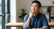 © Efan - Asian man thinking at office desk.