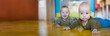 © guruXOX - Two baby twin brothers are crawling on a bright yellow floor. One twin is closer to the camera while the other is in the background. The room has a playful environment. Empty space for text