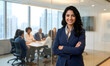 © Design curator - Confident Indian Businesswoman Portrait with Arms Crossed and Corporate Team Meeting in Background