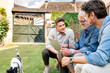 © Westend61 - Three smiling men of different age using tablet in garden