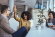 © Dragana Gordic - Friends Celebrate Success With A High Five In A Modern Office Meeting Room