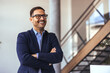 © Dragana Gordic - Confident Businessman Smiling In Modern Office Setting With Glasses, Staircase Background, And Professional Vibe