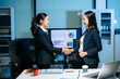 © Nuttapong punna - Two businesswomen shaking hands in modern office after agreement. Professional partnership, corporate teamwork, trust, negotiation, success and business collaboration.