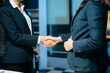 © Nuttapong punna - Two businesswomen shaking hands in modern office after agreement. Professional partnership, corporate teamwork, trust, negotiation, success and business collaboration.