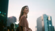 © dodotone - Positive beautiful smiling portrait single business asian woman standing at outdoors city building background