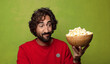 © kues1 - young adult bearded man. popcorns and movie concept