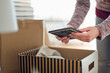 © Westend61 - Close-up of woman unpacking cardboard box in new home