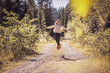 © Westend61 - Girl running and jumping on a forest path, having fun