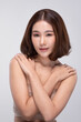 © 220 Selfmade studio - Beautiful young asian woman with short brown hair looking at camera feeling happy enjoy healthy skin care routine and cosmetic spa treatment with fresh face expression on isolated grey background