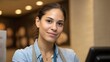 © Bussakon - A young friendly female employee with a warm smile standing confidently behind a counter in a professional service environment