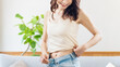 © Trickster* - 室内でウエストラインを見る笑顔の女性の健康的なライフスタイル, Smiling woman showing her waistline indoors, healthy lifestyle concept