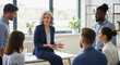 © Awais - Experienced Female Executive Mentoring Diverse Startup Team in Modern Open-Plan Office Space