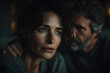 © Selvam - Middle aged man comforting middle aged Caucasian woman by placing hand on her shoulder, both sitting indoors, showing support and empathy during conversation