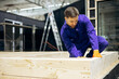 © Petro - Male worker cutting wooden bars for modular buildings