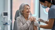 © Alex - Happy senior woman receiving vaccine injection from nurse in face mask. Elderly patient getting flu shot at medical clinic
