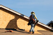 © Eduardo Barraza - Construction worker installs roofing underlayment on a wood framed house under construction, illustrating residential roofing preparation and weatherproofing prior to final roof covering
