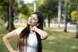 © Dejan - A young woman enjoys stretching in a green park, showcasing relaxation and outdoor fitness moments.