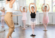 © JackF - At ballet school, children are engaged in choreography lesson. Near ballet bare in center of hall, students learn to perform basic elements. Children repeatedly make movements, learn stage production