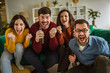 © Miljan Živković - Friends cheering and celebrating victory watching sports at home