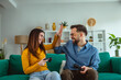 © Miljan Živković - Young couple playing video games and high five on couch