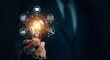 © Lianlian Liang - Hand holding glowing light bulb surrounded by education and business strategy icons for knowledge and innovation concept