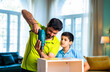 © StockImageFactory - Indian Father demonstrates furniture assembly skills to curious child at home