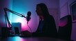 © Dece Std - Woman recording podcast in room lit by neon lights, focused on laptop
