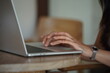 © BOONSOM - Close-up of hands typing on a laptop keyboard, remote work or digital nomad lifestyle.