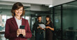 © Stock 4 You - Web banner middle-aged manager woman ceo using cell phone mobile with business people on background. Smiling mature ceo businesswoman investor holding smartphone in office typing, working. Copy space