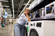© Ivan Traimak - Woman enjoying a visit to an appliance store while exploring washing machines and dryers