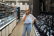 © Ivan Traimak - Senior woman shopping for kitchen faucets while talking on her phone in a hardware store