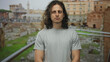 © Krakenimages.com - Man standing with visible forearms and relaxed posture facing camera at building ruins walkway in daylight; quiet contemplation.
