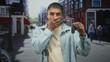 © Krakenimages.com - Man holding car keys and covering his eye with one hand while showing a key fob on a busy city street, wearing light jacket and beige shirt; frustration.