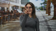 © Krakenimages.com - Woman with glasses points finger and outstretched hand toward camera on street terrace restaurant outdoors; confidence invitation.