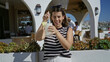 © Krakenimages.com - Woman sipping a frosty cocktail through a straw at a building bar counter with sunglasses on head and a pineapple garnish; relaxed vacation.