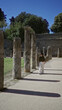 © Krakenimages.com - Woman walking among ancient stone columns in building pathway wearing sunglasses and white trousers; serenity travel history.