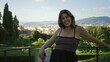 © Krakenimages.com - Woman leans on railing at a viewpoint over florence building, bare shoulders visible while smiling and holding sunglasses; travel joy.