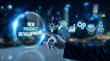 © Ramzan - Professional hand touching a glowing virtual circle with new product development text and process icons in a dark digita