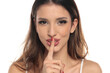 © vladimirfloyd - Studio shot of a brunette woman making shh gesture with finger on lips, happy expression, portrait, headshot, on a white background