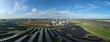 © AmazingAerialAgency - Aerial view of solar panels glinting under a vast blue sky, contrasting with the industrial complex, Biomass Nr. 3 power plant, Boston, United Kingdom.