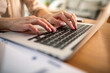 © Davor - Woman typing on laptop at home office desk